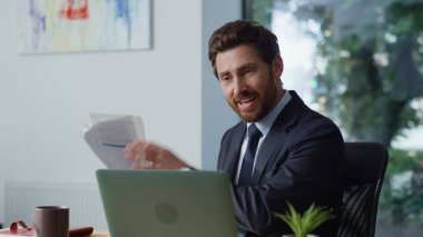 İş koçu ışık ofisinden görüntülü konuşmayı arıyor. Neşeli iş adamı ortağıyla sanal görüşme yapıyor. Gülümseyen orta yaşlı yönetici panoramik iş yerinde online konuşma dizüstü bilgisayarına danışmanlık yapıyor