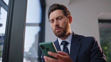 Hayal kırıklığına uğramış yönetici cep telefonuyla sessiz otel lobisinde tek başına oturuyor. Kötü haber okuyan üzgün adam büyük vitrinlerdeki kafaya dokunan akıllı telefon mesajları okuyor. Endişeli adam içeride reaksiyon sorunları yaşıyor.