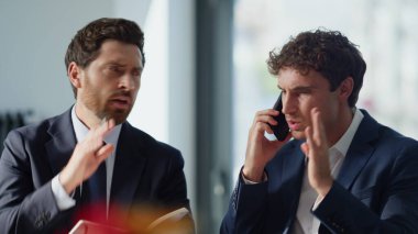 Akıllı telefondan konuşan iki yeni yetme hayal kırıklığına uğramış. Umutsuzluğa kapılmışlar. Dolap kapanırken sorun yaşıyorlar. Ofisteki iş arkadaşları çağrıyı sonlandırıyor ve birlikte çalışıyorlar. Genç işadamları kötü haberlerden hoşlanmadı