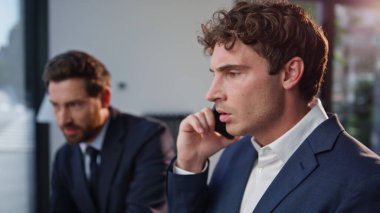 İş yerindeki gergin iş arkadaşları cep telefonunu arıyor. Sinirli iş arkadaşları kötü haberlere tepki veriyor. Akıllı telefon konuşmalarını bitiriyorlar. Stres hissediyorlar. İki hoşnutsuz yönetici iş kaybından endişeli