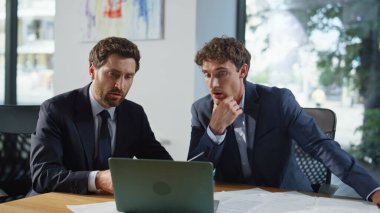 İş adamları web kamerası laptopuna evraklarını gösteriyor. Ofis toplantı odasında görüşme yapıyorlar. İki yönetici iş anlaşmasını video görüşmesiyle tartışıyor. Mutlu çalışan belgeyi uzaktan sunuyor