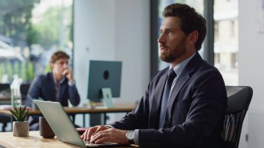 Panoramik ortak çalışma dizüstü bilgisayarında odaklanmış girişimci. Klavyeyi daktilo etmekle meşgul bir işadamı. Çalışma alanındaki harcamaları hesaplıyor. Düşünceli muhasebeci bütçe planlama bilgisayarını kapatıyor