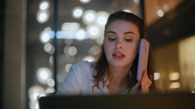 Karanlık modern iş yerindeki çalışan bilgisayara yakın çekim deniyor. Profesyonel yönetici cep telefonu konuşmalarıyla ilgili projeyi tartışıyor. Akşamüstü akıllı telefondan konuşan meşgul bir kadın işçi..