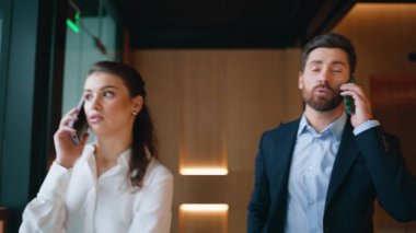 Ofisteki iş arkadaşları cep telefonlarıyla yürüyen şirket koridorunu kapatmaktan bahsediyorlar. Kendine güvenen iş adamları iş telefonlarını ayrı konuşuyorlar. Dost canlısı kadın sakallı iş adamıyla meseleyi tartışıyor..