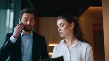 Ofis koridorunda sekreterle cep telefonuyla konuşmakla meşguldüm. Genç bir kadın iş adamlarıyla belgeleri tartışıyor. Patronun akıllı telefonu, iş kadını da evrakları kontrol ederken konuşuyor.