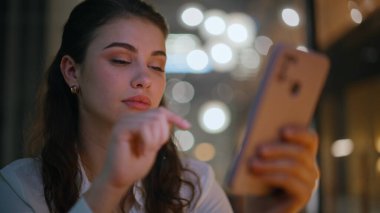 Kendine güveni tam bir iş kadını. Akıllı telefonları dinliyor. Akşam ofis kapanışında online alışveriş yapıyor. Gece evinde cep telefonu mesajı okuyan gülümseyen bir kadın. Neşeli esmer, internet iletişiminin tadını çıkarıyor..