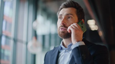 Ofiste cep telefonuyla konuşan bir işletmeci. Akıllı telefondan konuşan kendine güvenen iş adamı ayakta çalışma koridorunu tartışıyor. Sakallı yakışıklı CEO ev telefonuyla ortakları arıyor..