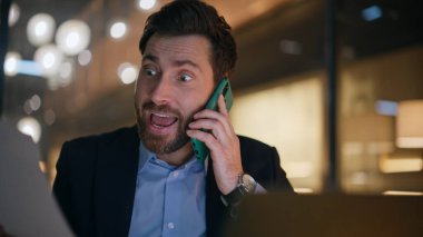 Sinirli direktör cep telefonunu arıyor. Finansal raporları yakın çekimde tutuyor. Öfkeli işadamı telefon konuşmalarındaki kağıtlardan şikayetçi. Sinirli yönetici akıllı telefondan bağırıyor..