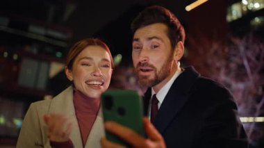 Heyecanlı iş çifti akşam üzeri cep telefonlarını arıyor. Karanlık modern bölgede başarılı olan gece iş arkadaşları akıllı telefon ekranlarını izliyorlar. Neşeli yeni başlayanlar 