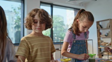 İlkokulda resim dersinde resim yapan yaratıcı çocuklar. Grup yetenekli öğrencileri yaratıcılığa ve renkli resimlere odaklandı. Resim dersinde resim kullanan sevimli okul çocukları..