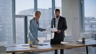 Acemi kurucular el sıkışma ofisi. Gülümseyen iş kadını işadamı, belgelerle birlikte çalışarak ortaklıktan keyif alıyor. Şehir manzarası panoramik kabinesinde evrakları inceleyen iki iş arkadaşı anlaşma yapıyor. 