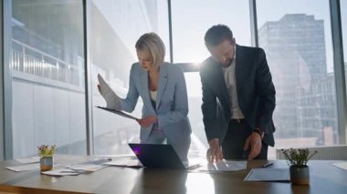 Modern şehir ofisindeki belgeleri inceleyen birden fazla iş arkadaşı. Bilgisayarla sohbet eden iyimser muhasebeciler. Finansal belgeleri inceleyen iş ortakları. Şirket ekibi raporun detaylarını doğruluyor