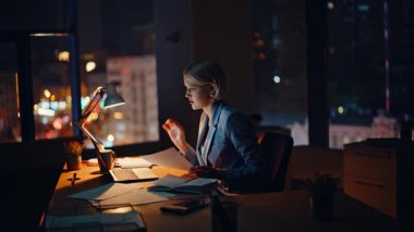 İş danışmanı video konferansında kağıtları analiz ediyor. Başarılı iş kadını çevrimiçi arayıp gülüyor. Bayan müdür sanal arkadaşça akşam toplantısında sözleşmeyi görüştü 