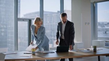 Başlangıç ortakları güneş ışığı ofisinde beş dakika veriyorlar. Belgeler üzerinde işbirliği yapan mutlu iş kadını işadamı. Şehir manzaralı şirket odasında kağıtları inceleyen iki iş arkadaşı anlaşma imzalıyor.