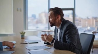 Deli avukatlar cam duvarlar ofisinde iş sorularını tartışıyorlar. İş adamı, kadınlarla duygusal konuşarak el kol hareketi yapıyor. Kızgın muhasebeci kadın işçiyle evrak hatası yüzünden tartışıyor. 