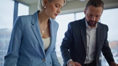 Muhasebeciler modern konferans salonunda kağıtları çeviriyorlar. Gergin iş adamları mali raporları kontrol ediyor birlikte çalışırken hata buluyorlar. Stresli iki iş arkadaşı belgeleri arıyor.