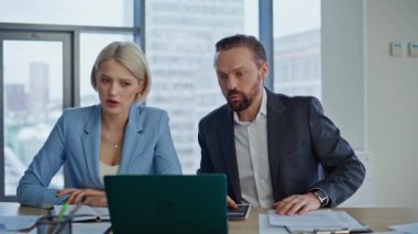 Sanal toplantıda tartışan duygusal iş arkadaşları ofiste dizüstü bilgisayara yakından bakıyor. Gergin meslektaşlar iş yerinde iş ortakları diye bağırıyor. Kızgın meslektaşlar dizüstü bilgisayarı kapatırken stres hissediyorlar