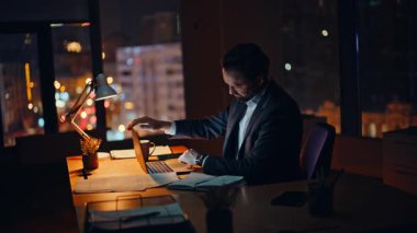 Karanlık Şirket 'in çalışma alanında çalışan geç bir yönetici. Yorgun işadamı dizüstü bilgisayarı kapatma işi fazla mesai yapmak için motivasyonsuz hissettiriyor. Yorgun, esneyen adam, sıkı çalışma gününü gece ofisinde tamamla.