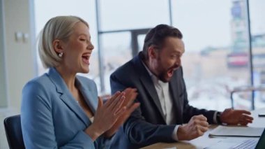 Şaşırtıcı iş adamları zafer kutlamaları yapıyorlar. Şehir merkezinde dizüstü bilgisayarı birlikte izliyorlar. Aşırı mutlu meslektaşlar duygusal olarak başarıya tepki veriyor. Mutlu iş arkadaşları beşli takım çalışmasından zevk alıyor