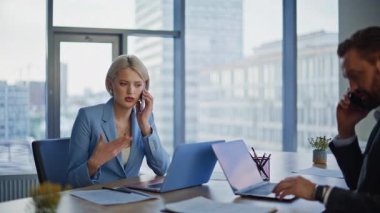 Ofis masasında mobil cihazlarla konuşan meşgul yöneticiler. Profesyonel iş arkadaşları akıllı telefonlarla sohbet ediyor ve ciddi tartışmalar yapıyorlar. Ekip üyeleri telefonları aktif olarak içeride kullanıyorlar. İş birliği