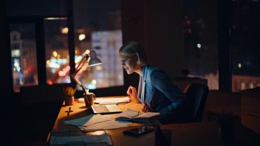 Kadın genel müdürün, gece kabinesinde otururken çekilmiş videoyla kavgası yakın plan. Stresli avukat sanal toplantıda belgelerin hatalı olmasından şikayetçi. Öfkeli iş kadını dizüstü bilgisayarını kapatıyor. 