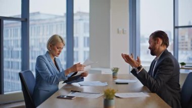 Girişimci, ofis masasında el sıkışarak iş adamıyla anlaşma yapıyor. Gülümseyen iş kadını, erkek meslektaşımla kontrat imzalıyor. Takım çalışması planlayan ortaklar