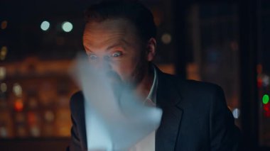 Portre manyağı CEO, gece vakti çalışan kabine işyerindeki video konferansında kavga ediyor. Stresli uzman, yakın çekimde doküman hatasından şikayetçi. Öfkeli iş adamı dizüstü bilgisayarın kapağını kapatıyor