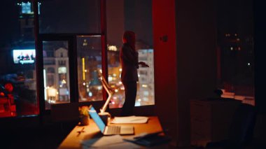 Gece çalışanı akıllı telefonu tek başına arıyor. İş kadını silueti gece lamba ışığında konuşuyor. Meçhul bayan yönetmen modern iş yerinde geç saatlere kadar sohbet ediyor.