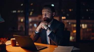 Yorgun işadamı, karanlık çalışma alanındaki çalışma masasında kendini yorgun hissediyor. Yorgun bir ofis çalışanı masaj yapan, geceleri bilgisayarını kapatmak için fazla mesai yapmayan şakaklara masaj yapıyor. Zor iş günü konsepti