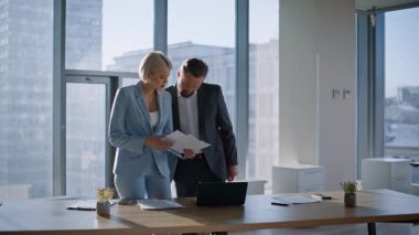 İş çifti panoramik ofiste belgeleri kontrol ediyor. İş arkadaşları, kapalı alandaki işleri çözmek için yatırımcıları arıyor. Profesyonel ekip, şehir görüşü kabinesinde bütçe sayımını tartışıyor.