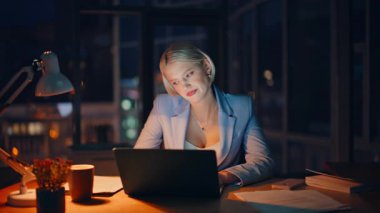 Yorgun iş kadını gece acentesindeki bilgisayar ekranında geç saatlere kadar çalışıyor. Yorgun kadın yöneticinin karanlık iş yerinde son teslim tarihi var. Çalışan çok çalışan bayan bilgisayar 