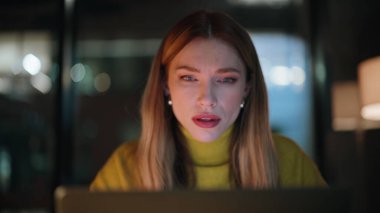 Girişimci gece geç saatlere kadar karanlık işyerinde oturmaktan yoruldu. Yorgun iş kadını gece ofisindeki bilgisayar kapağını kapatan şakaklara dokunuyor. Yorgun kadın serbest çalışan, fazla mesai baş ağrısı çeken..