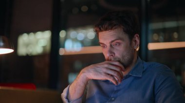 Tükenmiş iş adamı, akşam geç saatlerde ofis kapanışında dizüstü bilgisayar kullanıyor. Gece işyerinde çalışan yorgun adam menejeri göz yorgunluğundan muzdarip. Çok çalışan girişimci bilgisayarın kapağını kapatırken uzak işi bitir.