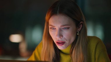 Portre gece çalışanı dizüstü bilgisayar ekranında stres hissediyor. Gece geç saatlerde karanlık ofiste bilgisayar başında çok çalışan bir iş kadını. Motivasyonsuz genç bir kadın. Mesai saatleri dışında serbest çalışan..