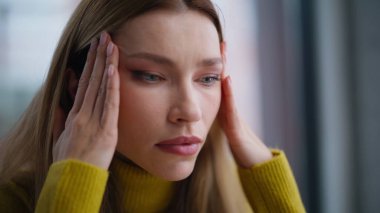 Modern ofiste baş ağrısı çeken hayal kırıklığına uğramış bir kadın. El ele tutuşup zor sorunları çözen işçilerin portresi. Kurumsal işlerde zihinsel baskı hisseden yorgun ve üzgün bir kadın..