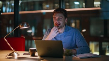 Gece geç saatlerde karanlık çalışma alanında girişimci planlama projesi. Gece ofisindeki laptopta çalışan çalışkan iş adamı, kopya defteri gibi görünüyor. Bilgisayar tarama web sitesinde fazla mesai yapan yaratıcı yönetici.