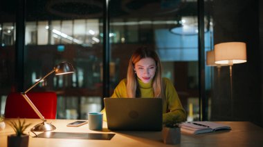 Girişimci gece ofis odasında proje geliştiriyor. Yaratıcı yönetici, karanlık iş yerindeki dizüstü bilgisayarlara bakarak bilgi topluyor. İş kadını akşamları bilgisayarları karıştırıyor.