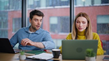 Modern ofiste iki meslektaşım projeye danışmanlık yapıyor. Pozitif kadın erkek birlikte çalışma alanında iş stratejisini tartışıyor. Şirket odasında iş birliği yapan gülümseyen iş arkadaşları pencere kenarında oturuyorlar..