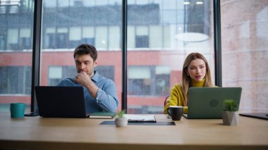 Şirketin ortak çalışma alanında dizüstü bilgisayarda çalışan iki iş arkadaşı. Modern iç mekanda panoramik pencereli bilgisayar geliştiren birkaç iş arkadaşı. İki yönetici takım çalışması..