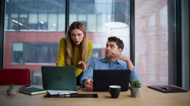 İşyerinde dizüstü bilgisayar gösteren bir şirket koçu. Kadın lider, ofis konferans odasında erkek yöneticiye iş konusunda yardım ediyor. İki şirket meslektaşı iş projesini tartışıyor.