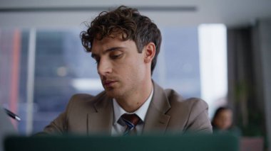 Düşünceli iş adamı iş yerinde dizüstü bilgisayarla oturuyor. Ofiste düşünceli esmer profesyonel düşünce.