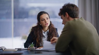 Profesyonel danışman, panoramik kabine ofisinde müşteriyle proje hakkında konuşuyor. Kendine güvenen bir kadın planlarını erkeklere anlatıyor.