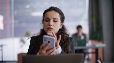 Ciddi bir şirket çalışanı cep telefonuna bakıyor ve yakın çekimde mesaj alıyor. Hüsrana uğramış endişeli iş kadını para okuyor. Bildirimi kaybetmiş.