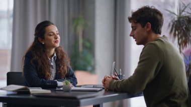 Gülümseyen yönetici şirket bürosunun kapanış masasında müşteriye danışmanlık yapıyor. Kendine güvenen iş kadını, erkeklerle belgeleri tartışıyor.