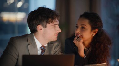 İş yerinde iş arkadaşlarıyla flört ederken bilgisayar ekranlarını yakın plan çekiyorlar. Karanlık ofiste sekreter kadına şaka yapan yakışıklı bir adam. Geç çalışan işçiler