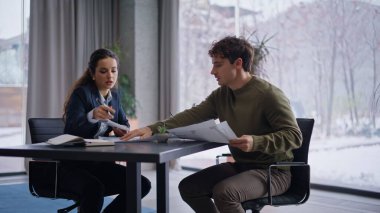 Yaratıcı ajans ofisinde erkek müşteriyle iç mimar planlama projesi. Toplantıda tasarım stratejisini destekleyen mutlu profesyoneller