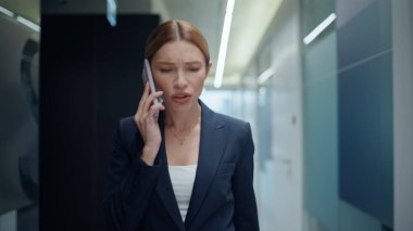 Kızgın iş kadını boş koridorda cep telefonunu tartışıyor. Duygusal bayan patron internetten azar işitiyor ve kötü bir konuşma yapıyor. Öfkeli kadın yönetici cep telefonu aramasını sonlandırdı.