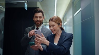 Meslektaşına akıllı telefonu gösteren bir bayan boş koridorda yürüyor. Arkadaş canlısı şirket çalışanları ofis koridorunda iş molası veriyorlar. Duygusal partnerler cep telefonlarını birlikte ararlar.