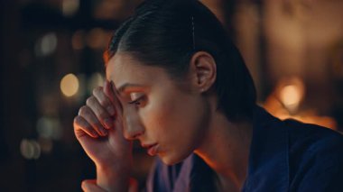 Karanlık çalışma alanı yakınında oturan yorgun bir uzman. Endişeli iş kadını gece vardiyasındaki iş krizini düşünüyor. Yorgun kadın çalışan profesyonel yorgunluk yaşıyor. Çalışma sorunu.