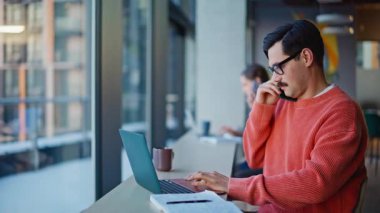 Pozitif danışmanlar açık işyerinde cep telefonlarını konuşuyorlar. Profesyonel erkek menajer ortak iş yerindeki kadın çalışana gülümsüyor. Kafede cep telefonuyla konuşan iki mutlu meslektaşım..